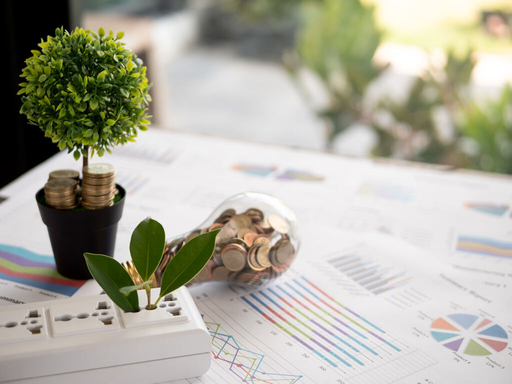 dicas para economizar energia Miniatura de árvore e lâmpadas sinalizando a energia sustentável